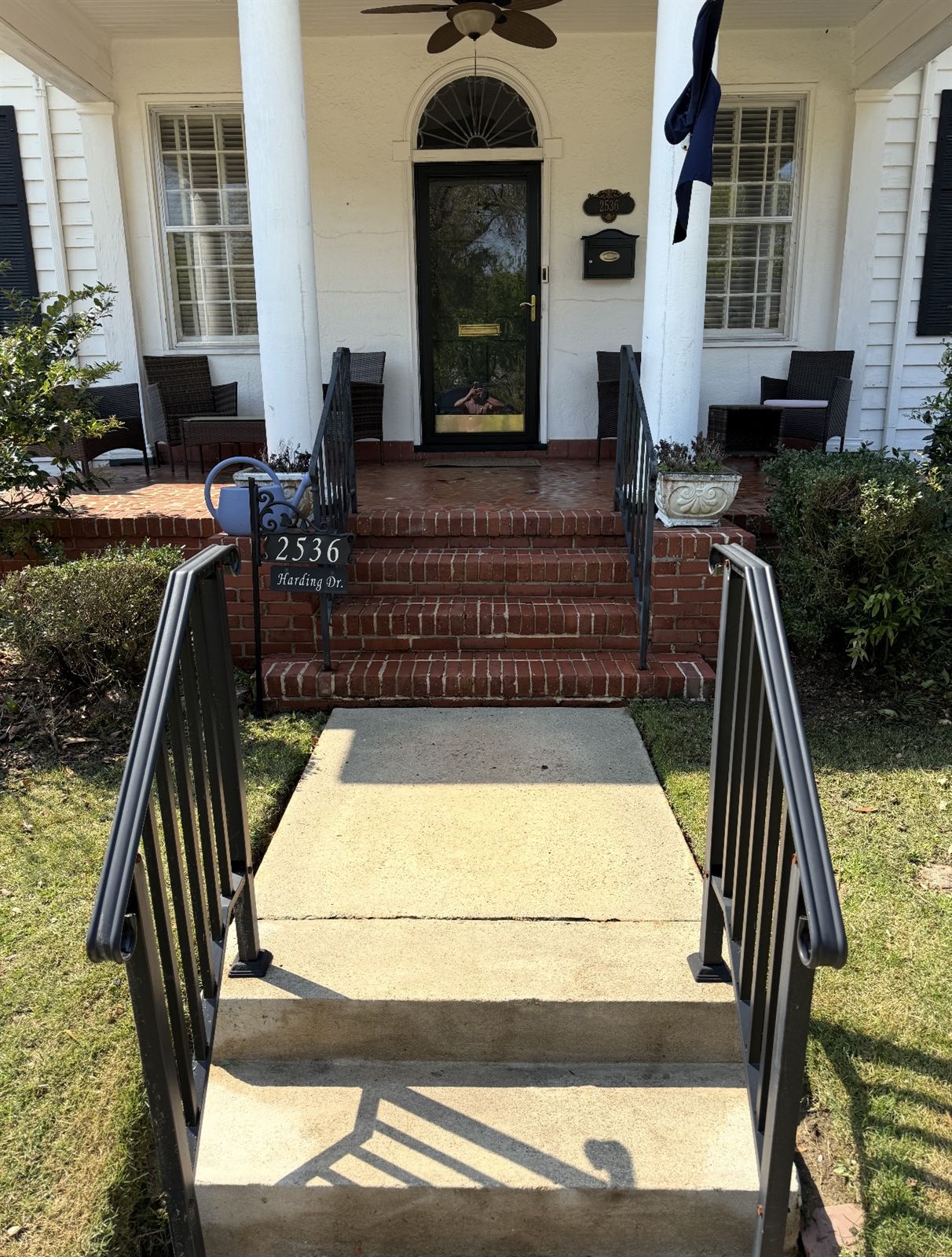 Clean concrete walkway and bright red brick front steps after pressure washing in Columbus, Georgia
