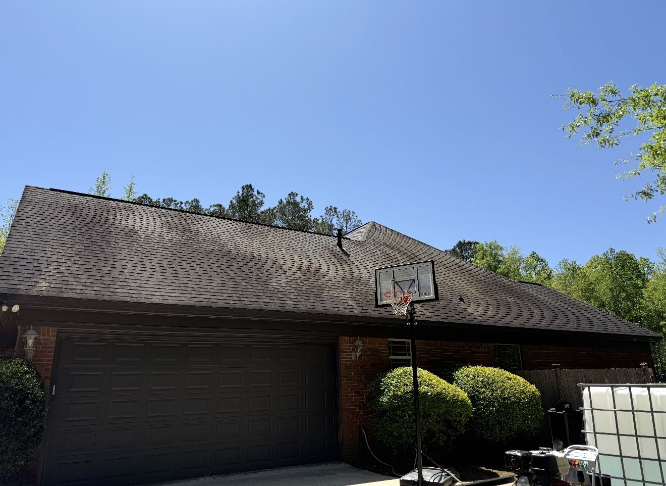 Shingle roof streaked with dark algae before soft wash roof cleaning in Columbus, GA